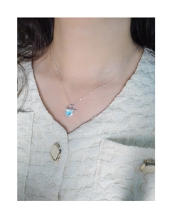 Detail of S925 silver necklace featuring a sea blue heart pendant on a female neck