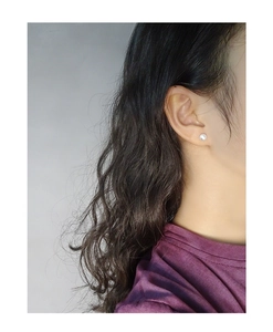 Detail showing a matte brushed ball stud earring on model for elegant everyday wear