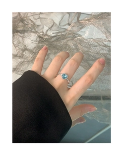 Close-up of a silver S925 heart ring featuring a light blue gemstone in a 4-prong setting