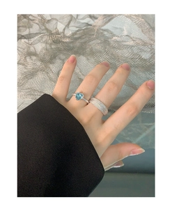 Detail view of S925 silver ring set with light blue heart gemstone and woven texture band