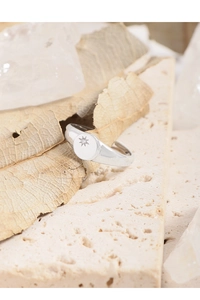 Detail of S925 sterling silver ring with starburst pattern and zircon on stone