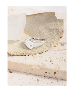 Detail of silver S925 ring showing etched starburst pattern and small zircon on round face