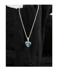 Détail d'un pendentif en pierre bleue en forme de cœur sur une chaîne en argent poli
