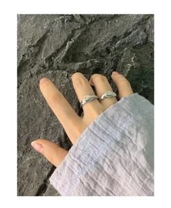 Close-up of dual minimalist silver rings featuring engraved star motifs on natural rocks