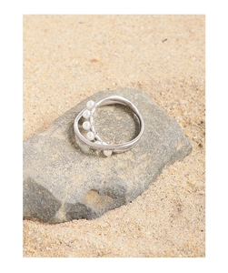 Macro detail of silver S925 ring featuring intertwined bands with pearls and cubic zirconia