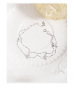 Détail du bracelet double couche en argent S925 avec breloques trèfle en zircone