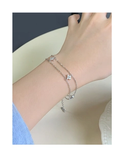 Détail du bracelet double couche en argent S925 avec breloques fleurs en zircon au poignet
