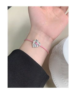 Close-up of pink woven rope bracelet featuring a textured S925 silver heart pendant