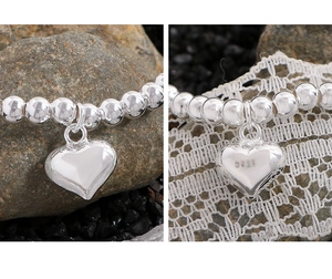 Macro d'un bracelet en perles d'argent S925 avec détail du pendentif coeur gravé