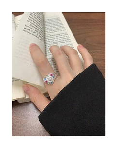 Close-up of S925 silver heart ring with colorful zircon stones on woman's finger