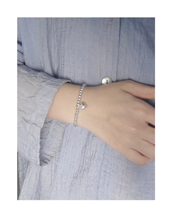 Vue détaillée d'un bracelet en perles d'argent S925 avec cœur porté au poignet
