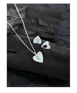 Macro shot of S925 silver heart necklace and stud earrings with blue crystal detail