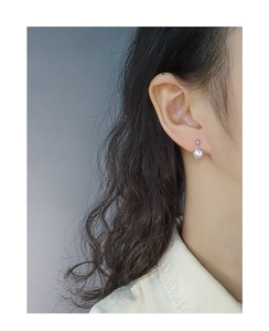 Close-up view of a minimalist S925 sterling silver shell mini stud earring on an ear.