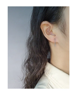 Detail of minimalist S925 silver long drop earring featuring beaded chain design on ear