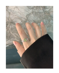 Detailaufnahme eines S925 Silberrings mit ovalem hellgrünem Kristall an der Hand