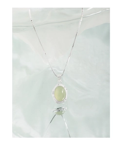 Macro view of light green oval crystal pendant on S925 sterling silver chain