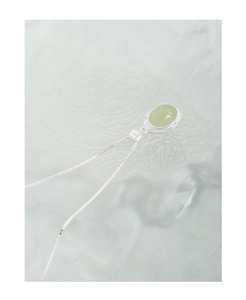 Macro view of the oval green crystal pendant on a delicate S925 sterling silver chain