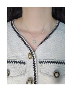Close-up of S925 silver necklace featuring an irregular oval green crystal pendant on a model