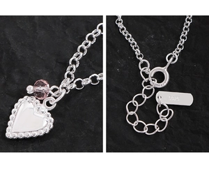 Macro detail of S925 sterling silver heart pendant with a pink crystal bead and spring clasp