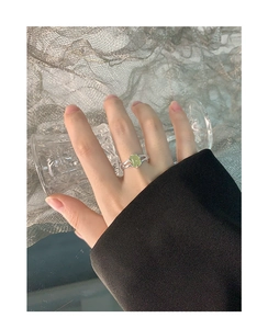 Detailaufnahme eines S925 Silberrings mit ovalem hellgrünem Kristall am Finger
