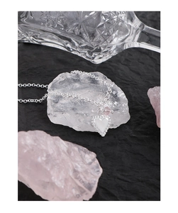 Detailed macro of a silver heart pendant with beaded edges and a small pink bead accent