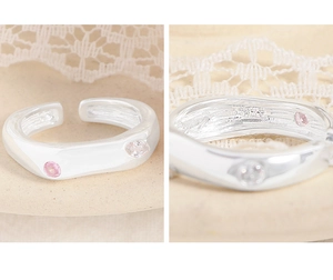 Close-up of S925 sterling silver ring with irregular wave design and pink zircon inlay