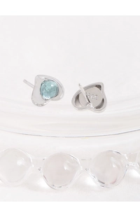 Macro shot of S925 sterling silver heart earrings with light blue translucent gemstones