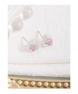 Macro shot of silver S925 asymmetric heart earrings with translucent pink crystal stones