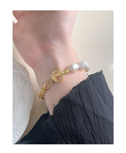 Détail du bracelet avec perles baroques et chaîne à maillons dorés et fermoir OT