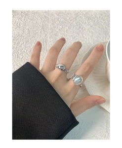 Detailed view of irregular silver liquid metal rings with sparkling grey oval stones