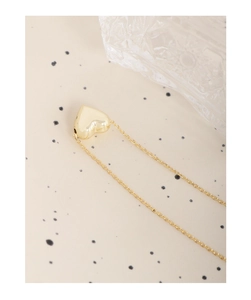 Détail du pendentif coeur 3D doré sur une chaîne délicate avec finition polie brillante