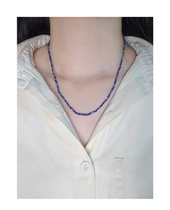 Macro-opname van fijne lapis lazuli kralenketting van S925 zilver op het sleutelbeen