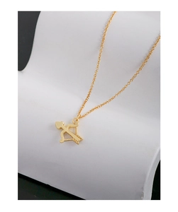 Dettaglio della collana con freccia di Cupido dorata e punta a cuore su supporto bianco