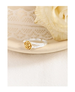 Detail of two-tone rose ring featuring gold petals and a textured silver branch band