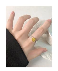 Detail showing an S925 silver ring with a golden rose flower design on hand