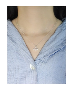 Dettaglio della collana freccia di Cupido in argento S925 su camicia a righe blu
