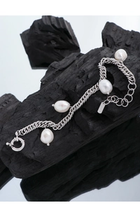 Close-up of S925 silver stamp on baroque pearl chain bracelet with mirror reflection