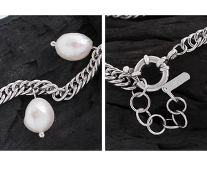 Macro detail of S925 sterling silver stamp and baroque pearl on the industrial chain link
