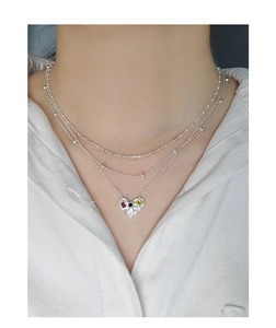 Détail d'un collier argenté multi-rangs avec pendentif cœur et zircons colorés sertis