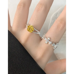 Set of S925 silver rings featuring a golden rose flower and gothic cross design on model hand