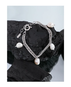 Detail of S925 silver Cuban chain bracelet featuring four natural baroque pearls on a dark stone