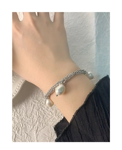 Detailed macro view of S925 silver double-chain bracelet with natural Baroque pearls