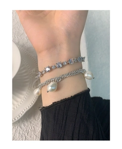 Close-up of S925 silver tennis bracelet with cubic zirconia and baroque pearl charms