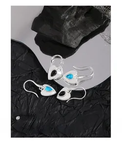Detail of S925 silver heart earrings with black onyx and sea blue drop-shaped stones
