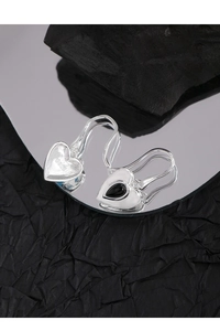 Detail view of heart-shaped S925 sterling silver earrings with black agate inlay