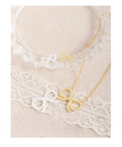Close-up of S925 sterling silver bowknot pendant necklaces in gold and silver finish