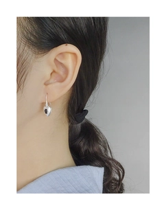 Close-up of S925 sterling silver heart earrings with black onyx on a female model