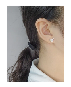 Detail of S925 silver heart stud earrings with colorful zircon stones on model's ear
