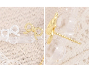 Detail of S925 sterling silver bow earrings with hallmark in gold and silver finishes
