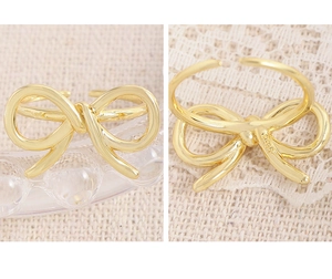 Detail of S925 sterling silver stamp on golden bow ring with adjustable band